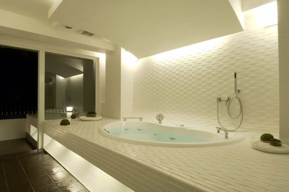 他の地域にある広いモダンスタイルのおしゃれなマスターバスルーム (大型浴槽、磁器タイル、セラミックタイルの床、黒い床) の写真