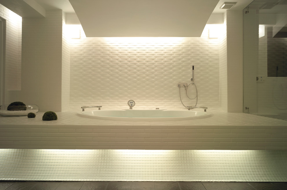 Idée de décoration pour une grande salle de bain principale minimaliste avec un bain bouillonnant, une douche double, un carrelage blanc, des carreaux de porcelaine, un mur blanc, un sol en carrelage de porcelaine, un sol noir et une cabine de douche à porte battante.