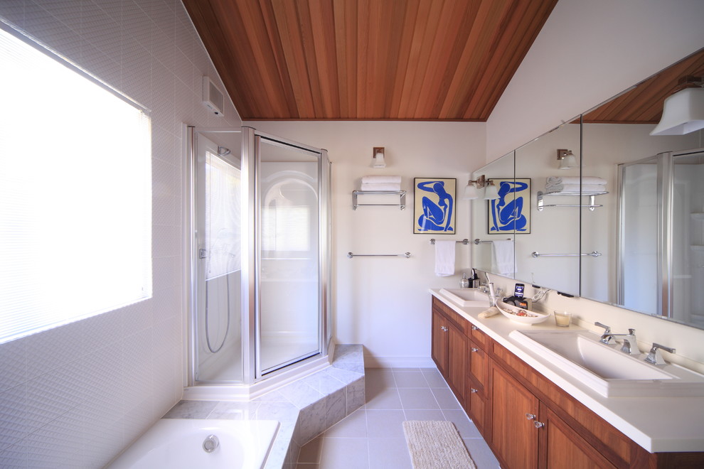 Aménagement d'une salle de bain méditerranéenne en bois brun avec une baignoire posée, un carrelage blanc, un mur blanc et un placard à porte shaker.