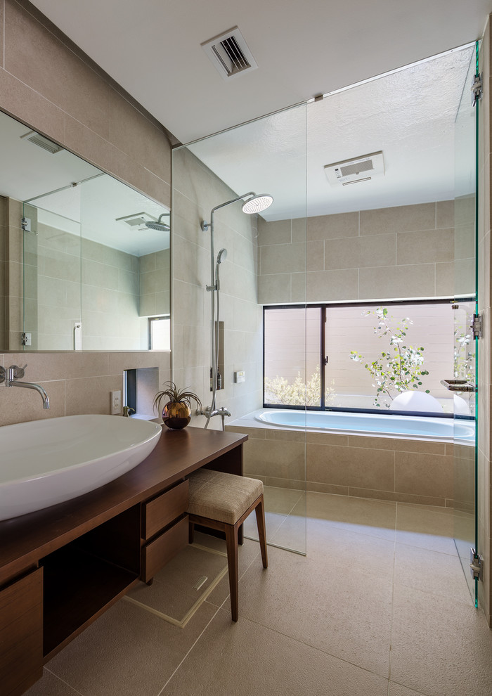 Пример оригинального дизайна: ванная комната в современном стиле с плоскими фасадами, фасадами цвета дерева среднего тона, ванной в нише, открытым душем, бежевыми стенами, настольной раковиной, столешницей из дерева, бежевым полом и открытым душем