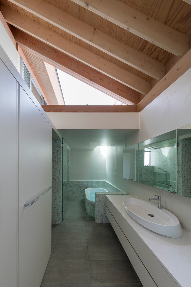Exemple d'une salle de bain tendance avec un placard à porte plane, des portes de placard blanches, un mur blanc et une vasque.