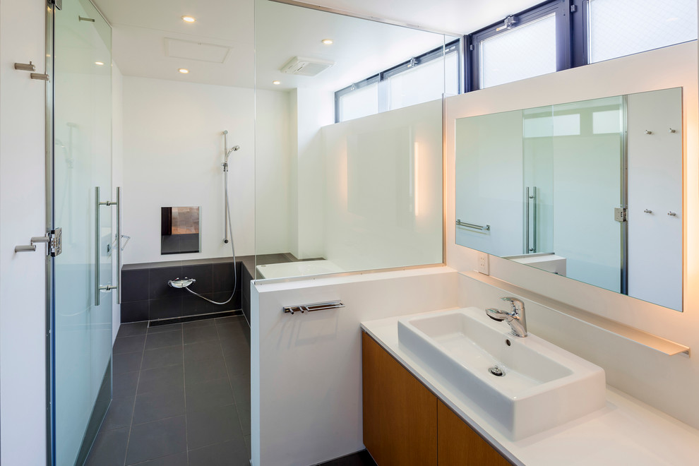 Inspiration för moderna badrum, med ett fristående handfat, släta luckor, skåp i mellenmörkt trä, ett platsbyggt badkar, en kantlös dusch, vita väggar och skiffergolv