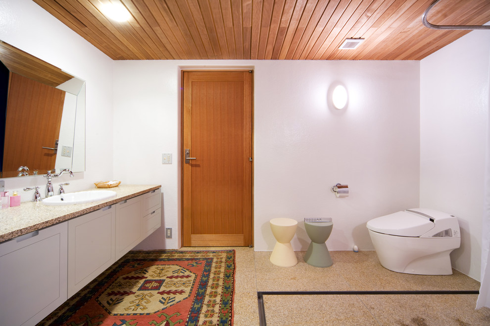 他の地域にあるアジアンスタイルのおしゃれな浴室 (フラットパネル扉のキャビネット、白いキャビネット、白い壁、オーバーカウンターシンク) の写真