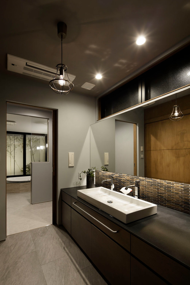 Ispirazione per una stanza da bagno etnica con ante lisce, ante in legno bruno, pareti grigie, lavabo a bacinella e pavimento grigio