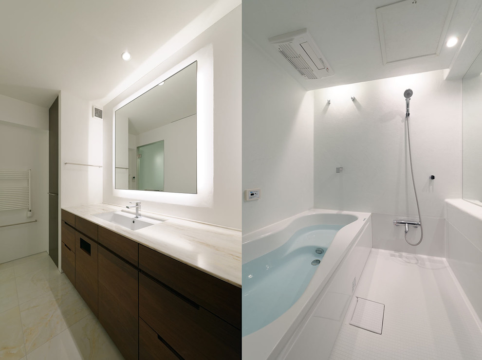 Exemple d'une salle de bain principale moderne en bois foncé de taille moyenne avec un placard à porte plane, un bain bouillonnant, un espace douche bain, un carrelage blanc, un mur blanc, un sol en carrelage de céramique, un lavabo encastré, un plan de toilette en surface solide et un sol beige.