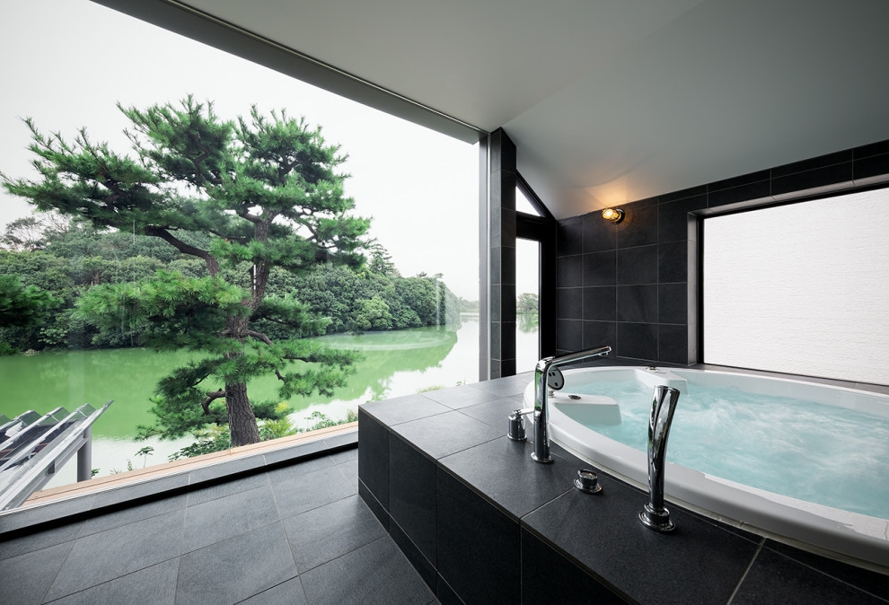 На фото: большая главная ванная комната в современном стиле с гидромассажной ванной, двойным душем, мраморным полом, черным полом, потолком из вагонки и мраморной плиткой