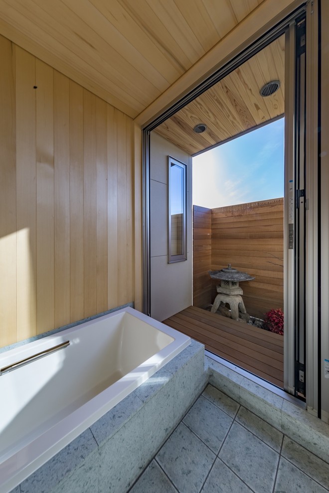 Foto på ett orientaliskt badrum, med ett hörnbadkar, beige väggar och grått golv