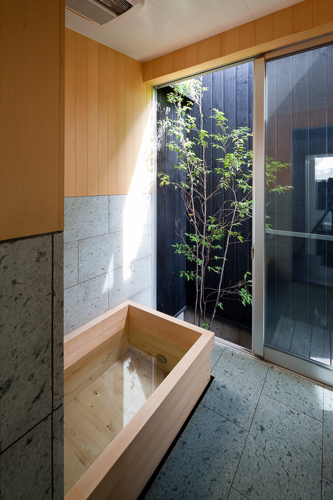 他の地域にある和風のおしゃれな浴室 (石タイル、コーナー型浴槽、マルチカラーの壁、グレーの床) の写真