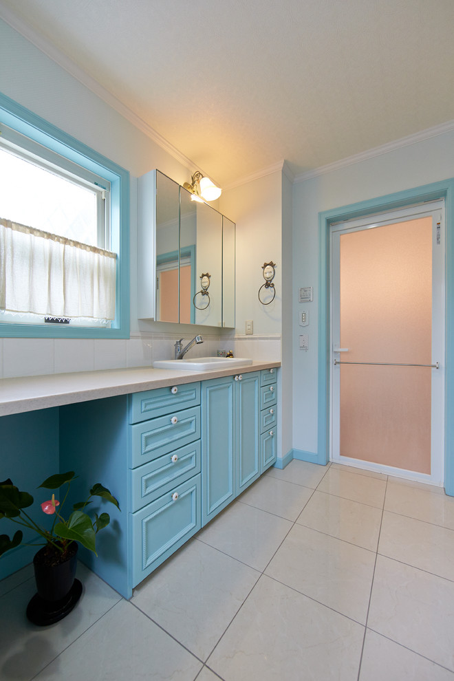 Imagen de cuarto de baño tradicional con armarios con paneles empotrados, puertas de armario azules, paredes blancas y suelo marrón