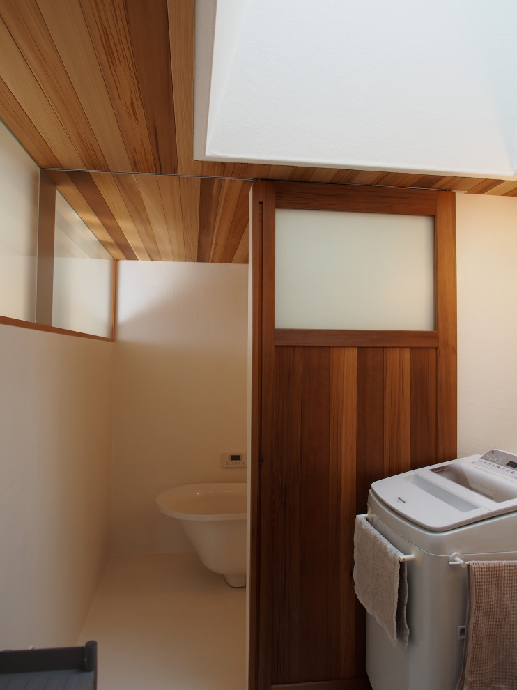 Свежая идея для дизайна: главная ванная комната среднего размера со стиральной машиной в стиле модернизм с белыми фасадами, отдельно стоящей ванной, открытым душем, писсуаром, белыми стенами, бетонным полом, подвесной раковиной, белым полом, открытым душем, тумбой под одну раковину, подвесной тумбой и деревянным потолком - отличное фото интерьера