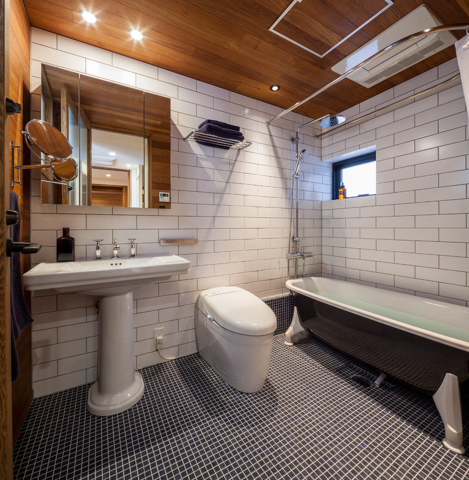 Идея дизайна: главная ванная комната в современном стиле с отдельно стоящей ванной, душем над ванной, унитазом-моноблоком, белой плиткой, белыми стенами, полом из мозаичной плитки, раковиной с пьедесталом и шторкой для ванной