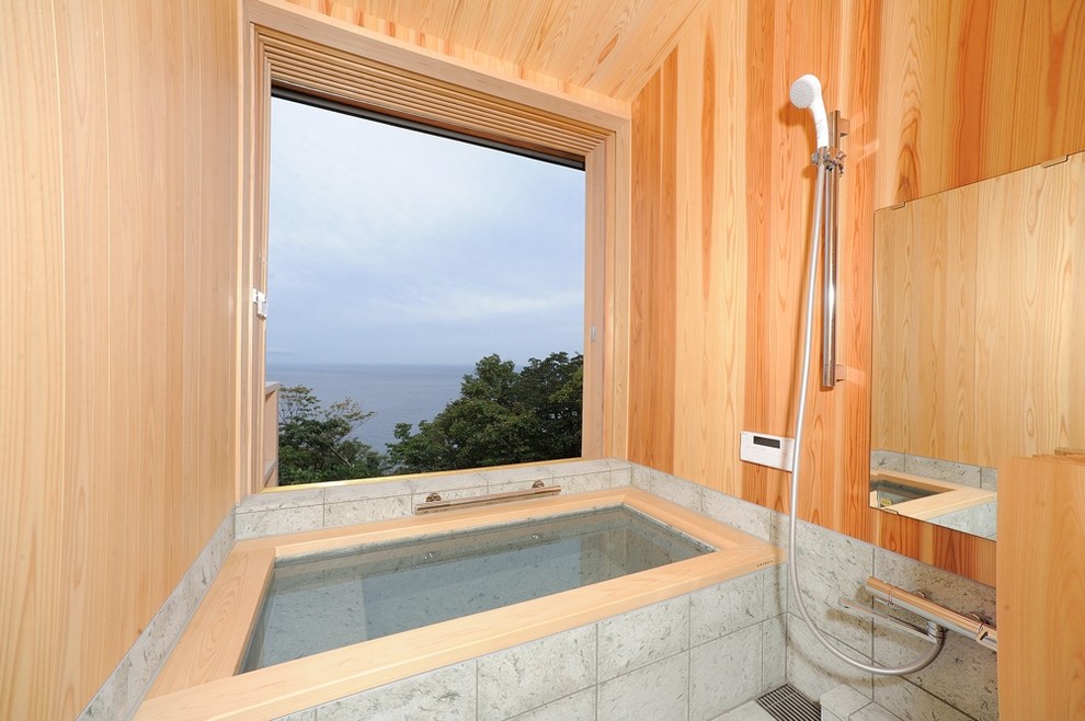 Cette photo montre une salle de bain moderne avec une baignoire d'angle, une douche ouverte, un mur marron, un sol gris et aucune cabine.