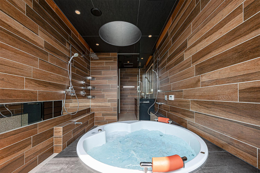 Modelo de cuarto de baño principal bohemio con bañera encastrada, baldosas y/o azulejos marrones, paredes marrones y suelo beige