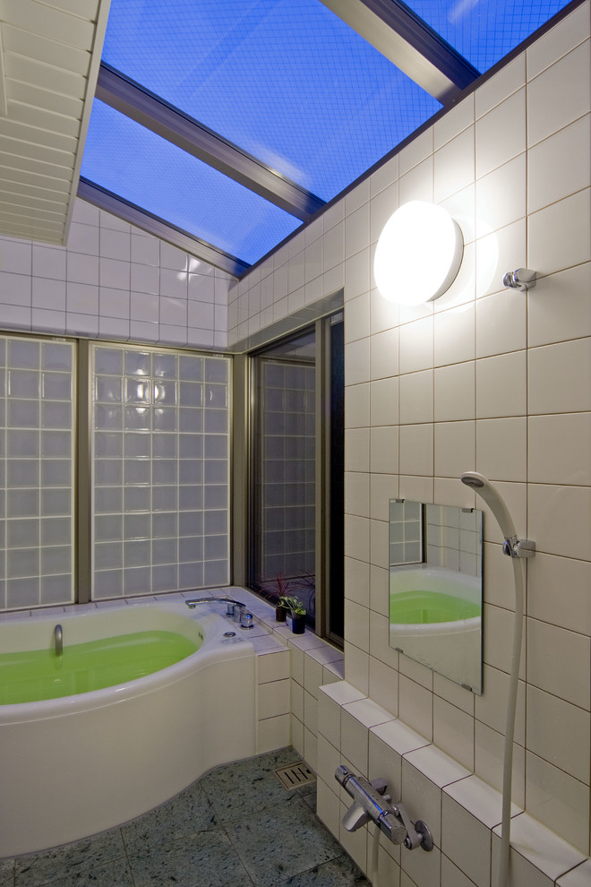 Foto di una stanza da bagno etnica con vasca ad angolo, doccia aperta, piastrelle bianche, pareti bianche, pavimento grigio e doccia aperta