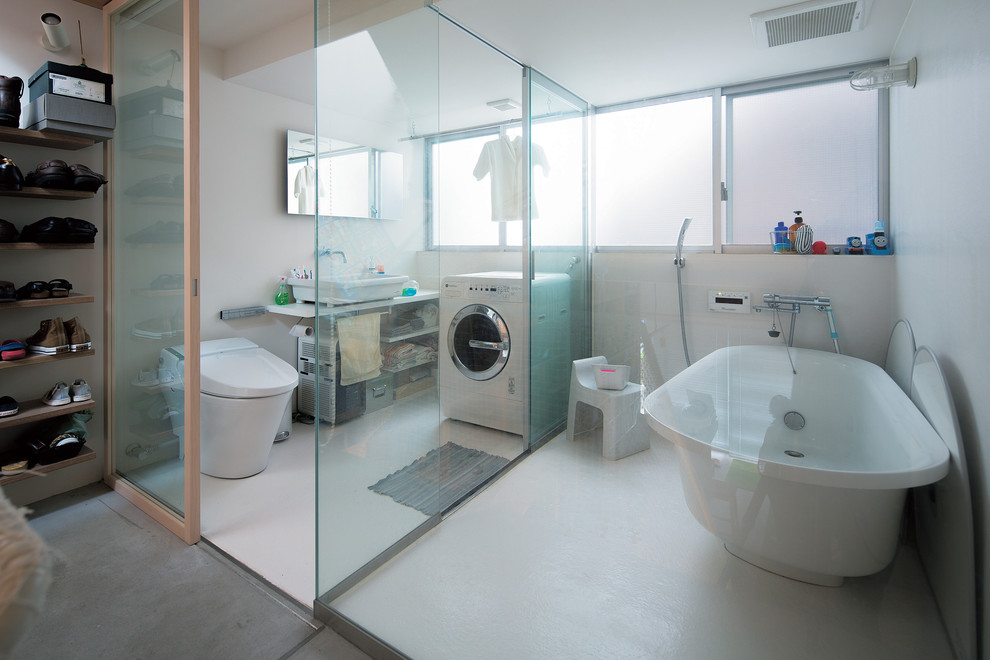 Immagine di una stanza da bagno contemporanea con vasca freestanding, WC monopezzo, pareti bianche e lavabo a bacinella