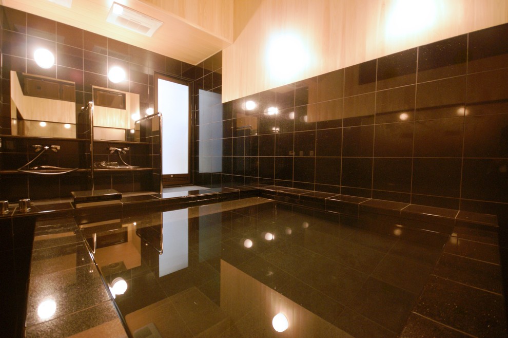 他の地域にあるラグジュアリーな巨大な和風のおしゃれなマスターバスルーム (大型浴槽、黒いタイル、石タイル、黒い床、オープンシャワー) の写真
