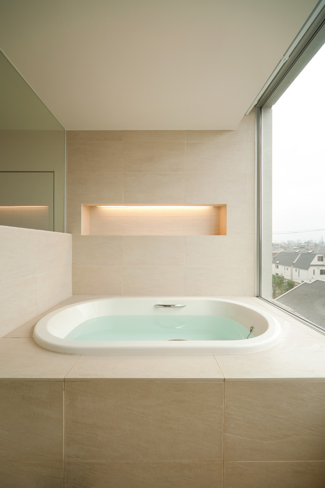 На фото: большая ванная комната в восточном стиле с бежевыми стенами, гидромассажной ванной и бежевым полом