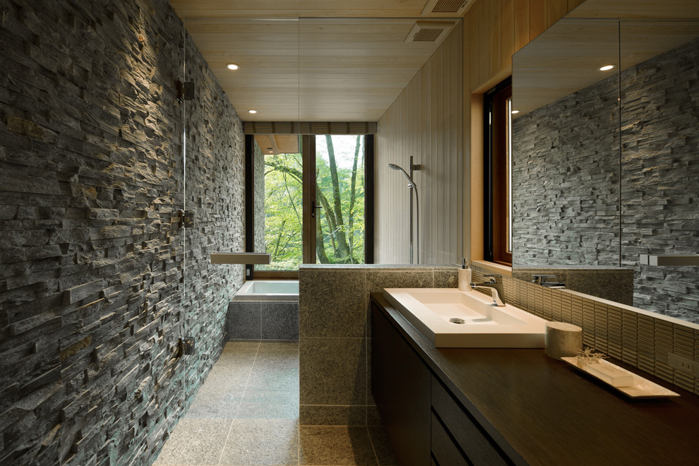 На фото: ванная комната в современном стиле с плоскими фасадами, угловой ванной, открытым душем, разноцветными стенами, серым полом и открытым душем с