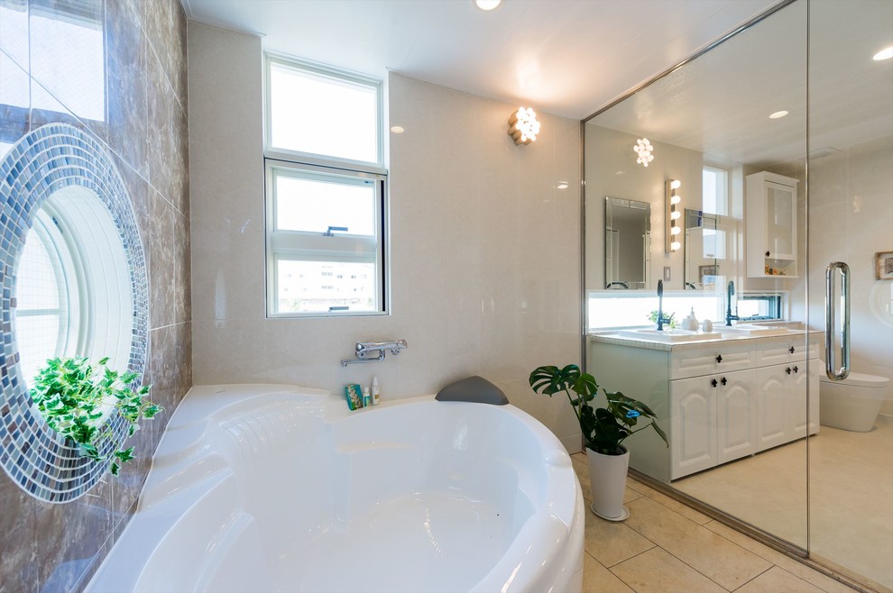 Idee per una stanza da bagno tradizionale con piastrelle beige, pavimento in cementine, pavimento beige, ante con riquadro incassato, ante bianche, vasca ad angolo e lavabo da incasso