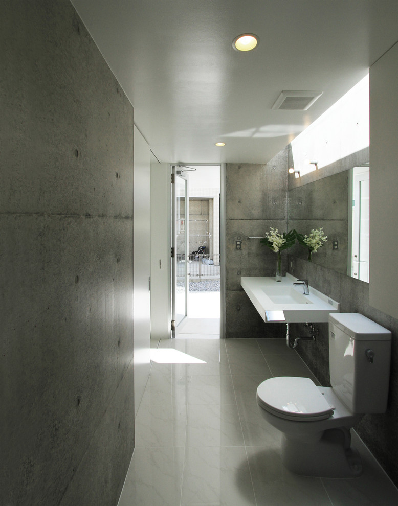 Immagine di una stanza da bagno moderna con pareti grigie, lavabo a consolle e pavimento grigio