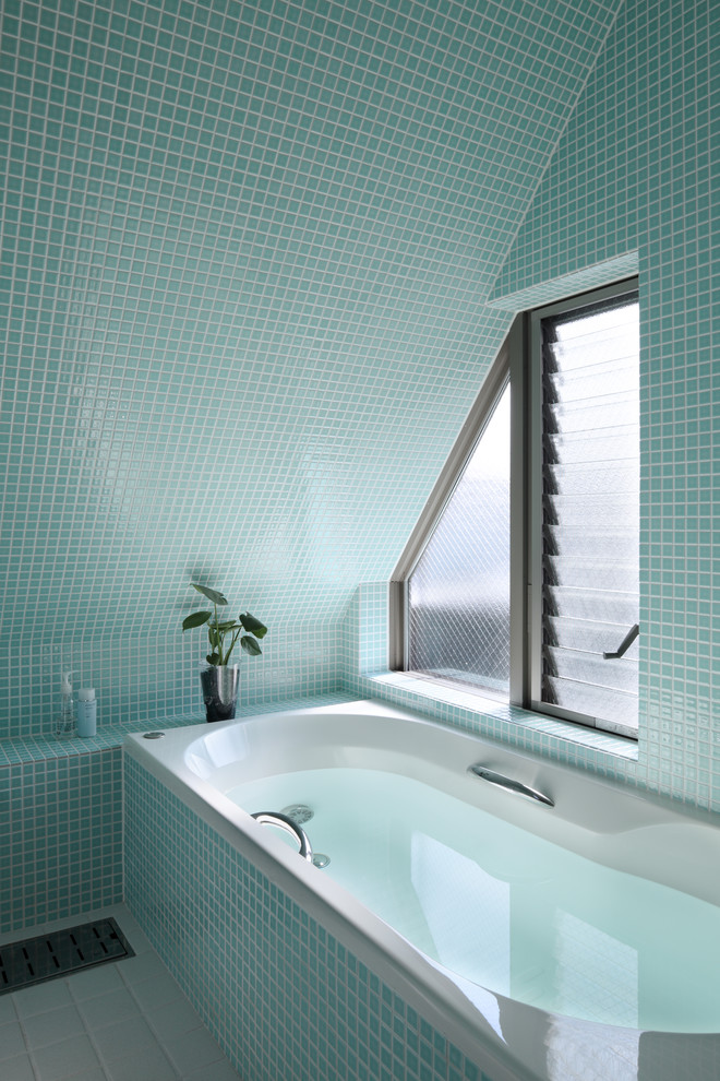 Modernes Badezimmer mit blauer Wandfarbe, blauem Boden und Eckbadewanne in Tokio