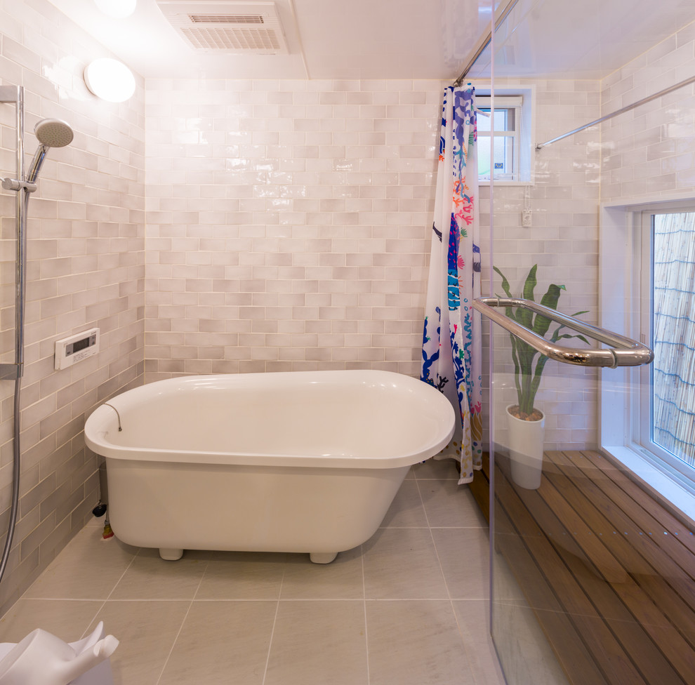 他の地域にある高級な中くらいな北欧スタイルのおしゃれなマスターバスルーム (置き型浴槽、洗い場付きシャワー、グレーのタイル、磁器タイル、磁器タイルの床、白い床、開き戸のシャワー) の写真