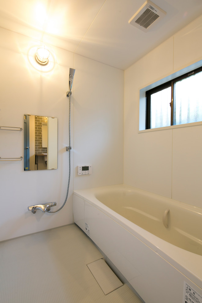 На фото: главная ванная комната в современном стиле с ванной в нише, душевой комнатой, белыми стенами, белым полом, душем с распашными дверями и панелями на части стены
