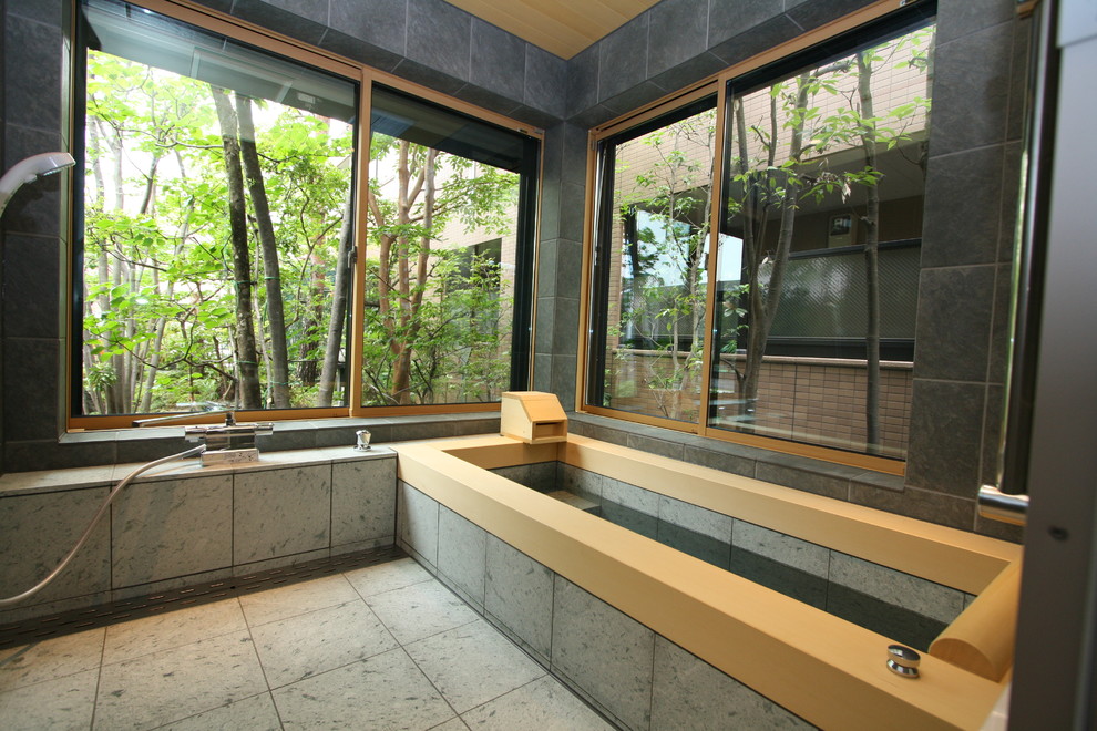 Foto di una stanza da bagno padronale etnica con piastrelle grigie, piastrelle beige, vasca ad angolo, doccia aperta, pareti grigie, pavimento grigio e doccia aperta