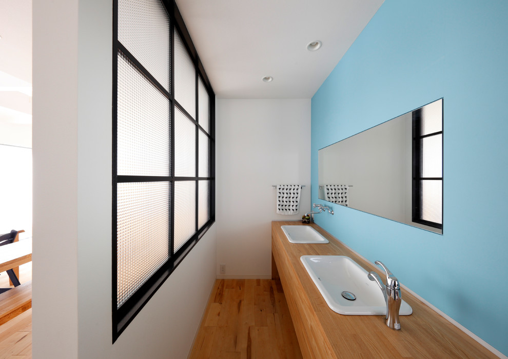 大阪にある北欧スタイルのおしゃれな浴室 (フラットパネル扉のキャビネット、中間色木目調キャビネット、青い壁、無垢フローリング、オーバーカウンターシンク、木製洗面台、茶色い床、ブラウンの洗面カウンター) の写真