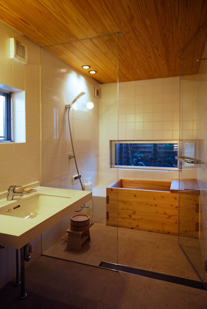 Idées déco pour une salle de bain asiatique avec une baignoire d'angle, une douche ouverte, un mur blanc, un plan vasque, un sol marron, aucune cabine et un carrelage blanc.