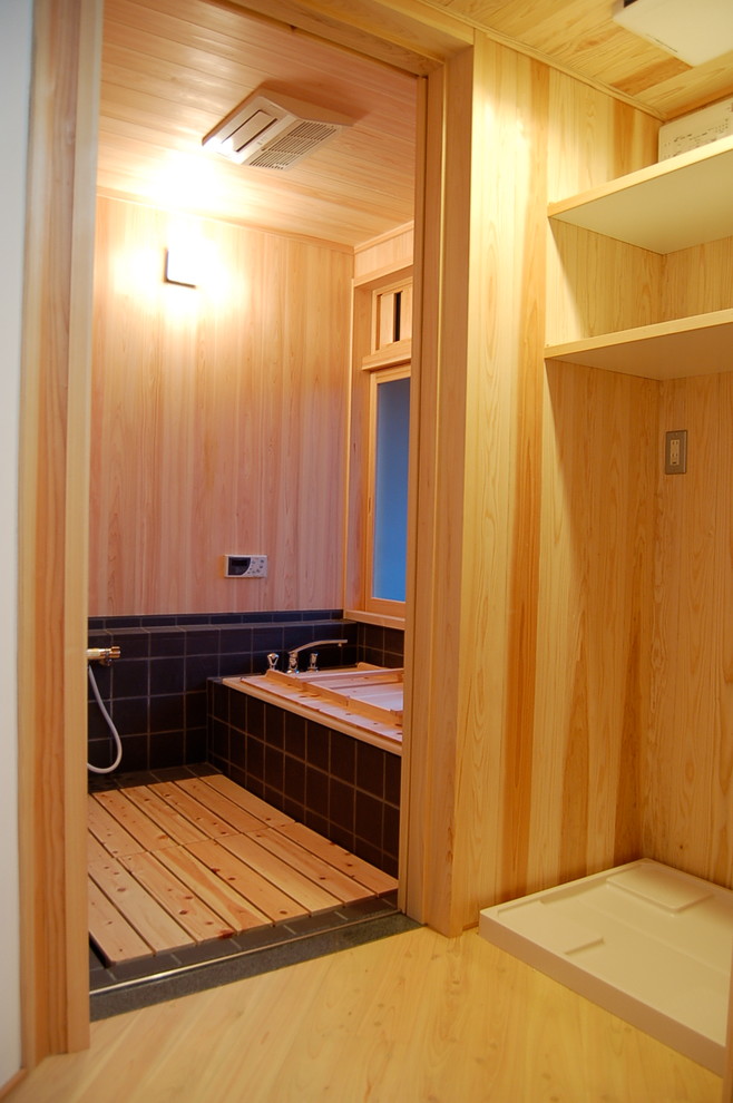 福岡にあるアジアンスタイルのおしゃれなマスターバスルーム (和式浴槽、オープン型シャワー、黒いタイル、磁器タイル、ベージュの壁、セラミックタイルの床、タイルの洗面台) の写真