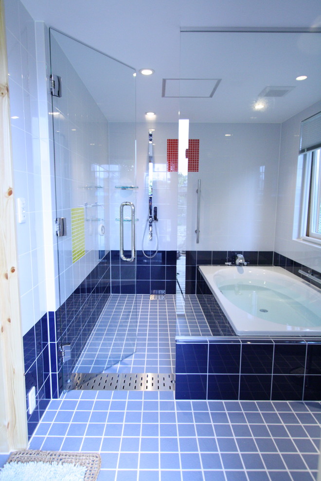 На фото: ванная комната в средиземноморском стиле с угловой ванной, открытым душем, разноцветными стенами, синим полом и душем с распашными дверями с