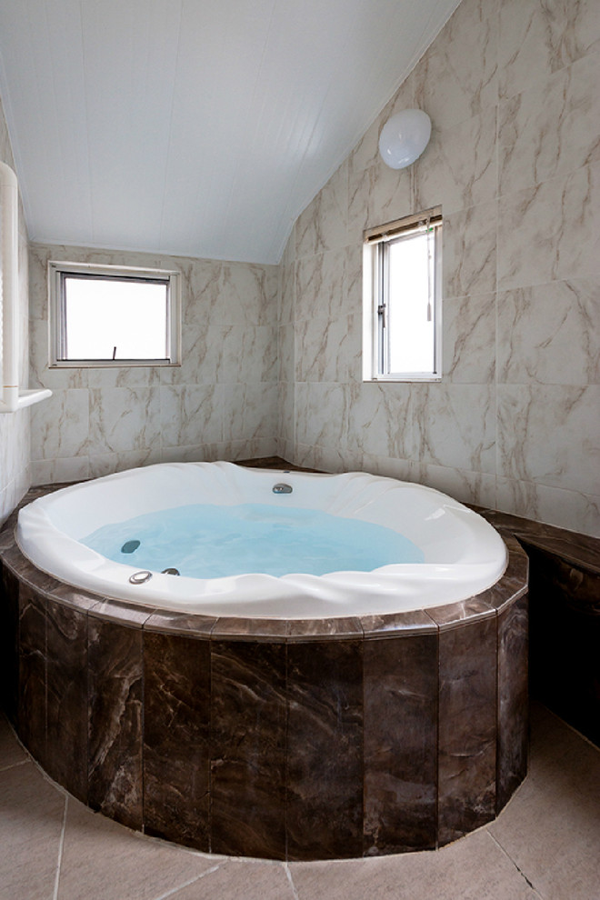 Inspiration pour une salle de bain traditionnelle avec un bain bouillonnant, un carrelage beige et un mur beige.