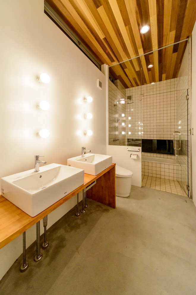 他の地域にあるビーチスタイルのおしゃれな浴室 (白い壁、コンクリートの床、ベッセル式洗面器、グレーの床) の写真