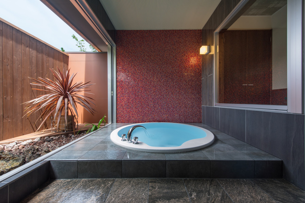 Стильный дизайн: ванная комната с стеклянной плиткой, красными стенами, полом из керамогранита и серым полом - последний тренд