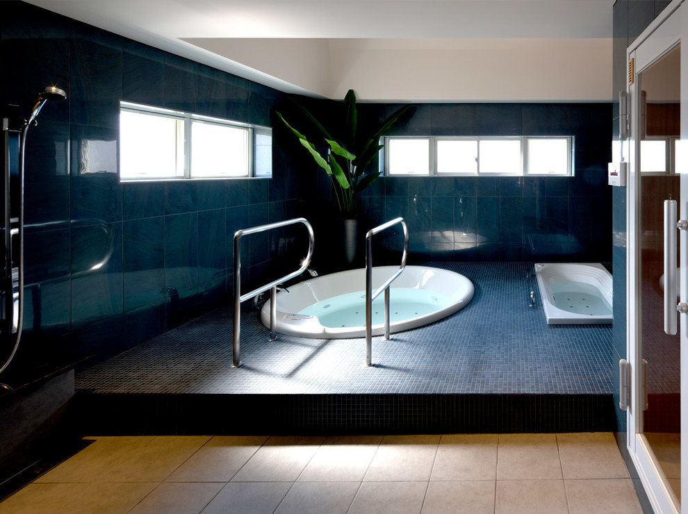Ispirazione per una stanza da bagno padronale contemporanea con vasca idromassaggio, piastrelle blu e pareti blu