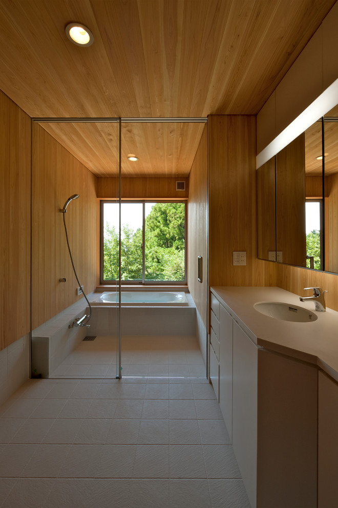 Пример оригинального дизайна: маленькая ванная комната в белых тонах с отделкой деревом в скандинавском стиле с белыми фасадами, душевой комнатой, белой плиткой, керамической плиткой, коричневыми стенами, полом из керамической плитки, столешницей из искусственного камня, белым полом, душем с раздвижными дверями, тумбой под одну раковину, встроенной тумбой, деревянным потолком и деревянными стенами для на участке и в саду