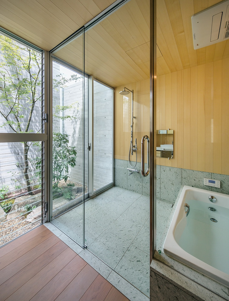 Стильный дизайн: ванная комната в восточном стиле с угловой ванной, открытым душем, коричневыми стенами, серым полом и открытым душем - последний тренд
