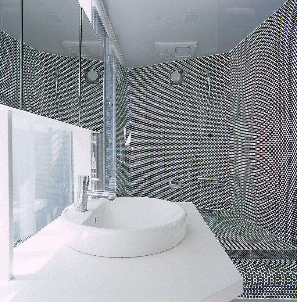 他の地域にあるモダンスタイルのおしゃれな浴室 (マルチカラーの壁、オーバーカウンターシンク、コーナー設置型シャワー) の写真