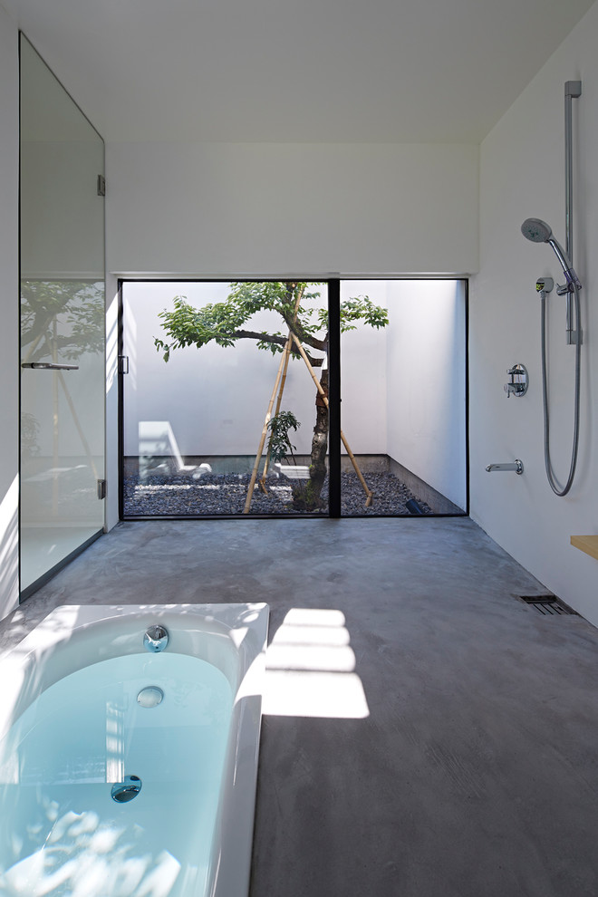 Inspiration pour une salle de bain asiatique avec une baignoire posée, une douche ouverte, sol en béton ciré et un sol gris.