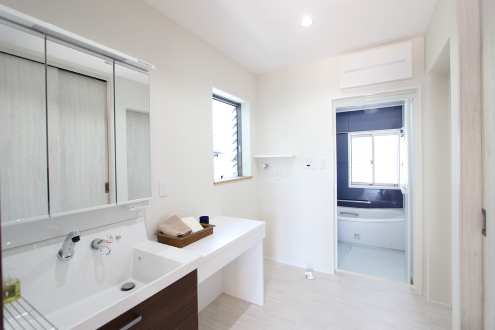 Esempio di una stanza da bagno contemporanea con pareti bianche, lavabo integrato e pavimento grigio