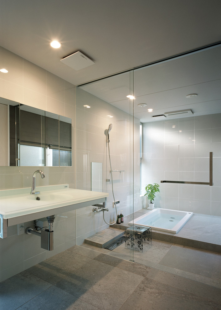 Modelo de cuarto de baño principal asiático con bañera encastrada, ducha abierta, baldosas y/o azulejos beige, paredes beige, lavabo suspendido y ducha abierta