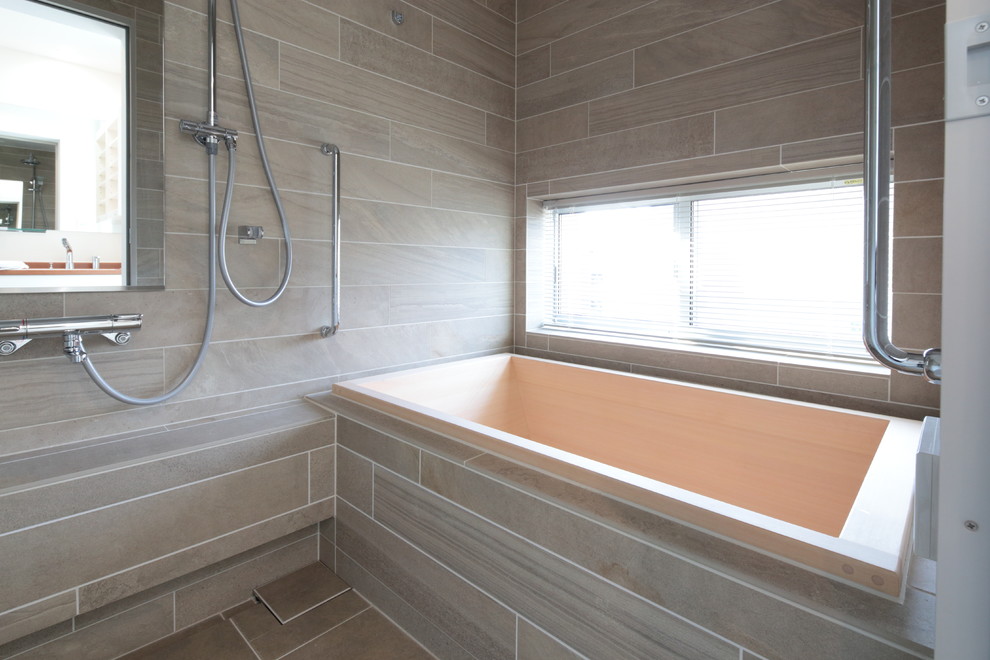 Inspiration for a contemporary ensuite bathroom in Tokyo with a shower/bath combination, beige tiles, brown walls, ceramic flooring and a built-in bath.