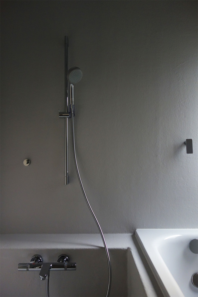 Modern inredning av ett badrum, med ett japanskt badkar, våtrum, vita väggar och med dusch som är öppen