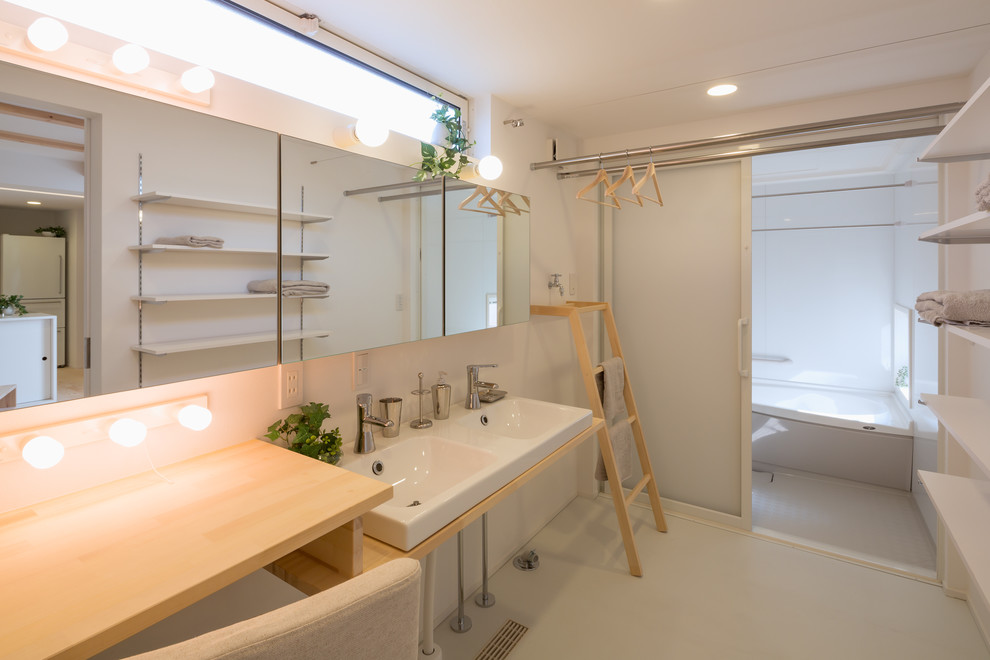 Bild på ett funkis badrum, med öppna hyllor, vita väggar och grått golv