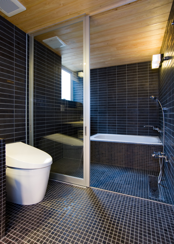 На фото: большая главная ванная комната в стиле лофт с коричневыми фасадами, отдельно стоящей ванной, открытым душем, унитазом-моноблоком, коричневой плиткой, керамогранитной плиткой, коричневыми стенами, полом из мозаичной плитки, врезной раковиной, мраморной столешницей, коричневым полом, душем с раздвижными дверями и бежевой столешницей с