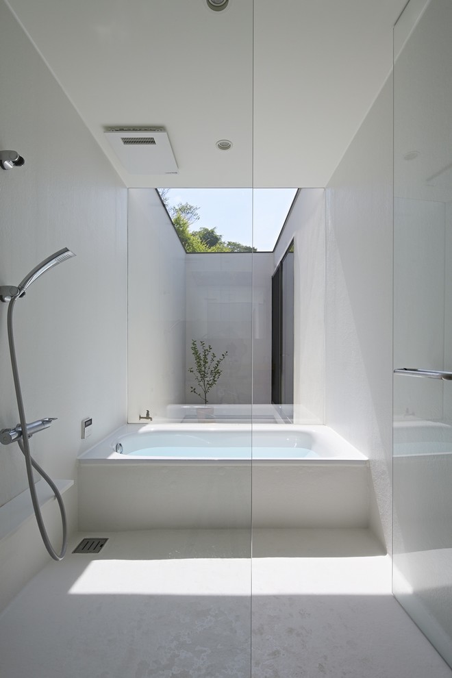 Photo of a modern bathroom in Tokyo with a corner bath, a walk-in shower, white walls, white floors and an open shower.