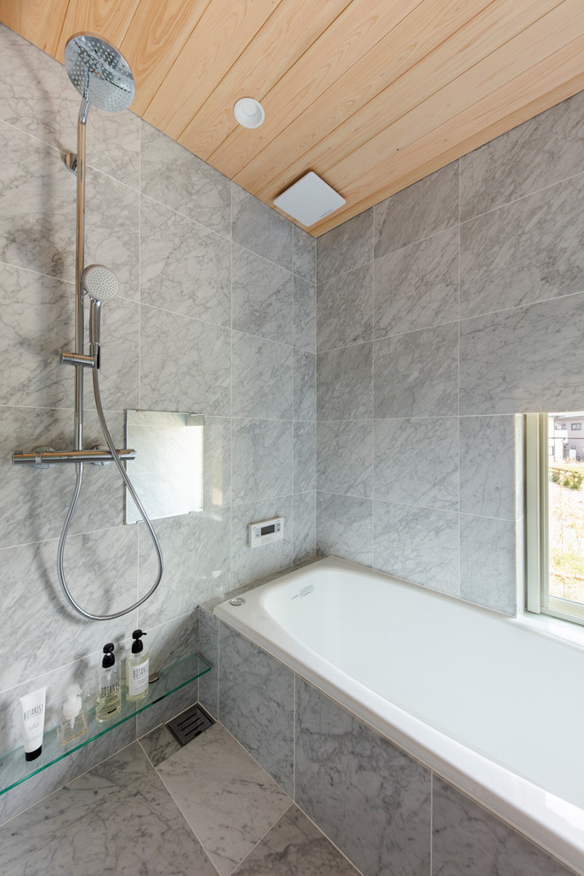Idées déco pour une salle de bain moderne avec une baignoire d'angle, une douche ouverte, un mur gris, un sol gris et aucune cabine.