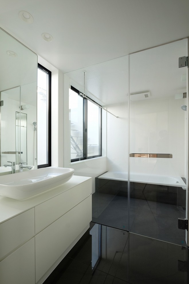 Modelo de cuarto de baño principal moderno con armarios con paneles lisos, puertas de armario blancas, bañera empotrada, paredes blancas, lavabo sobreencimera y ducha con puerta con bisagras