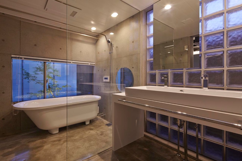 大阪にあるインダストリアルスタイルのおしゃれな浴室 (置き型浴槽、グレーの壁、コンクリートの床、横長型シンク、オープンシャワー) の写真